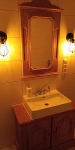 a bathroom with a sink and a mirror and lights at Gästehaus Stolzalpe in Stolzalpe +47 photos