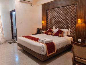 a bedroom with a large bed with a large headboard at Grand Milestone in Mysore