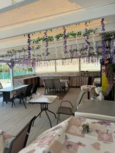 a restaurant with tables and purple flowers hanging from the ceiling at RESIDENTS IONIAN (BED AND BREAKFAST) in Argostoli