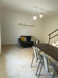 a living room with a couch and a table and chairs at Departamento zona centro in Villa María