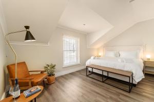 a bedroom with a bed and a chair and a table at Story Haus in Stellenbosch