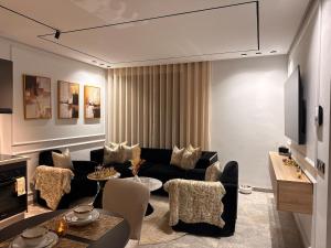 a living room with a black couch and chairs at Jolie studio plein centre Casablanca in Casablanca