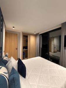 a bedroom with a large white bed with blue pillows at Jolie studio plein centre Casablanca in Casablanca