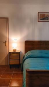 a bedroom with a bed and a lamp on a night stand at Casa Vallina - Garden & Mountain View in Castion