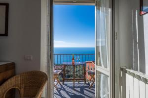 a room with a balcony with a view of the ocean at Creuza de Cinque Terre Apartment in Volastra