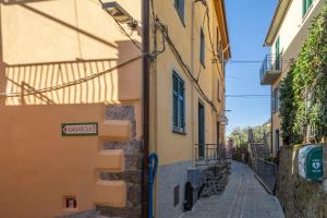 an alley with a sign on the side of a building at Creuza de Cinque Terre Apartment in Volastra