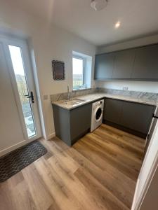 a kitchen with a sink and a dishwasher at Perceval Road, Stornoway Town in Stornoway +32 photos