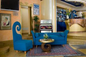 a lobby with a blue couch and a table at Hotel La Gradisca in Rimini