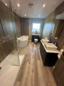 a bathroom with two sinks and a tub and a shower at Perceval Road, Stornoway Town in Stornoway