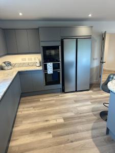 a kitchen with wooden floors and a refrigerator at Perceval Road, Stornoway Town in Stornoway