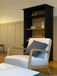 a room with a chair and a book shelf at The Old Shop Apartment in Rathmullan