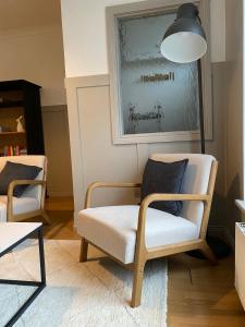 a living room with two chairs and a lamp at The Old Shop Apartment in Rathmullan