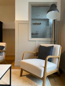 a living room with a chair and a painting at The Old Shop Apartment in Rathmullan +24 photos