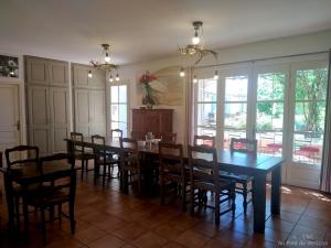 a dining room with a long table and chairs at AU PIED DU VENTOUX in Flassan