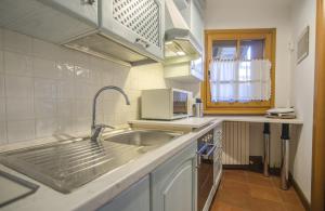 a kitchen with a sink and a microwave at Un angolo di relax sulle Dolomiti ampezzane in Cortina dʼAmpezzo