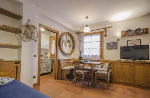 a living room with a table and a television at Un angolo di relax sulle Dolomiti ampezzane in Cortina dʼAmpezzo