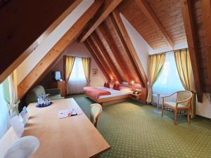 a attic room with a bed and a table and chairs at Hotel Post Jungingen in Jungingen +25 photos