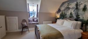 a bedroom with a large bed with a painting on the wall at Craigbuie Guesthouse in Killin
