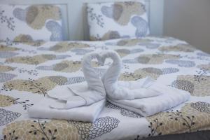 two towels shaped like swans sitting on a bed at M&M apartma in Bohinj +23 photos
