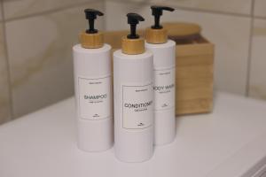 a group of four white bottles on a counter at M&M apartma in Bohinj