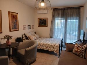 a bedroom with a bed and a couch and a window at Magdalena & Bambino apartments in Sarti