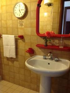 baño con lavabo y reloj en la pared en Villa Maria, en Mondello 35 fotos más