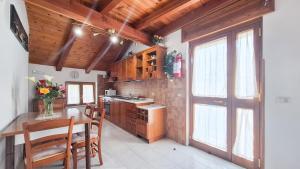 a kitchen with wooden cabinets and a table with chairs at Il Rifugio nelle Stelle in Agerola +2 photos