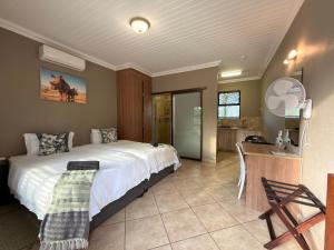 a bedroom with a large bed and a kitchen at My Africa Adventure Farm in Hoedspruit