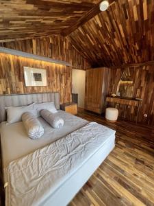 a bedroom with a large bed with wooden walls at YSR Himalaya Resort in Mantaak