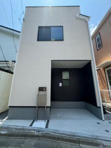 a building with a parking lot with a garage at HB Home TOKYO in Tokyo