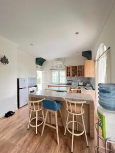 a kitchen with a large kitchen island with blue bar stools at YSR Himalaya Resort in Mantaak