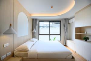 a bedroom with a large bed and a window at Premium 2BR near Kamala Beach, Pool, Gym & Shuttle Bus in Phuket +174 photos