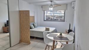 a small room with a table and a bed and a window at LoftPoint Rosario, Pileta, Solarium y Terraza con vista al Río in Rosario