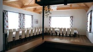 a room with chairs and a table and two windows at Domki Leśne Zacisze in Baczyn