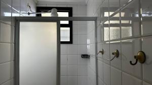 a white shower with a door in a bathroom at Apartamento Satel Praia in Itanhaém +35 photos