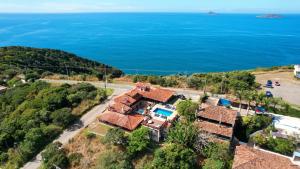 an aerial view of a house with the ocean in the background at Pousada Mirante dos Papagaios in Búzios