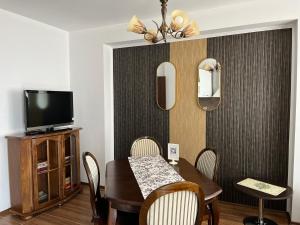 a dining room with a table and a television at Apart di Landi in Ravda