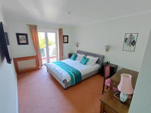 a bedroom with a bed and a table and a window at Estalagem De Colares in Sintra