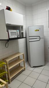 a kitchen with a refrigerator and a microwave at Apartamento Satel Praia in Itanhaém