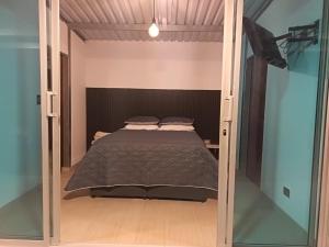 a bedroom with a bed inside of a glass door at Cabaña - Macanal in Macanal
