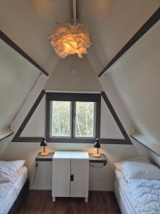 a room with two beds and a window in a attic at Bois d' Hibou in Durbuy