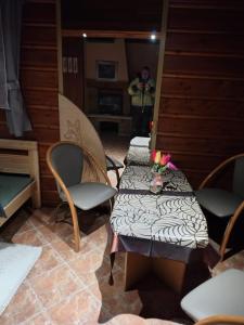 a room with two tables and two chairs and a person holding flowers at Agroturystyka pod Pstragiem in Zawoja +21 photos