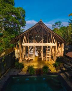 a house with a pool in front of it at Bamboo House - Ecobreeze in Sidemen