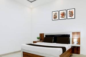a bedroom with a large bed with three pictures on the wall at Castle in Bharatpur