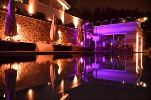 - une piscine avec des lumières violettes la nuit dans l'établissement Zeno Suites, à San Zeno di Montagna