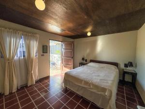 a bedroom with a bed and a door to a patio at Neska Polita Hostel in Juayúa