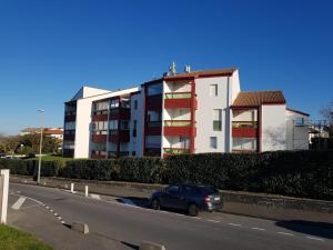 a car driving down a road in front of a building at Agréable Studio Face à l'Océan in Anglet