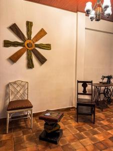 a room with chairs and a clock on the wall at Neska Polita Hostel in Juayúa +54 photos