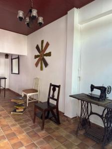 a room with a table and a sewing machine on a wall at Neska Polita Hostel in Juayúa