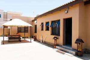a patio with an umbrella next to a house at Selamu Self Catering in Walvis Bay